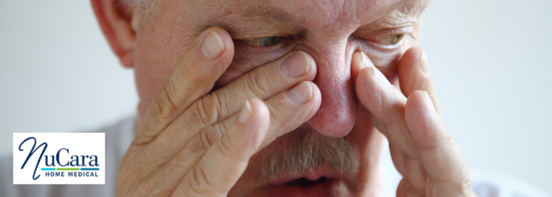 Older man pressing fingers into nose and sinuses to show he is congested