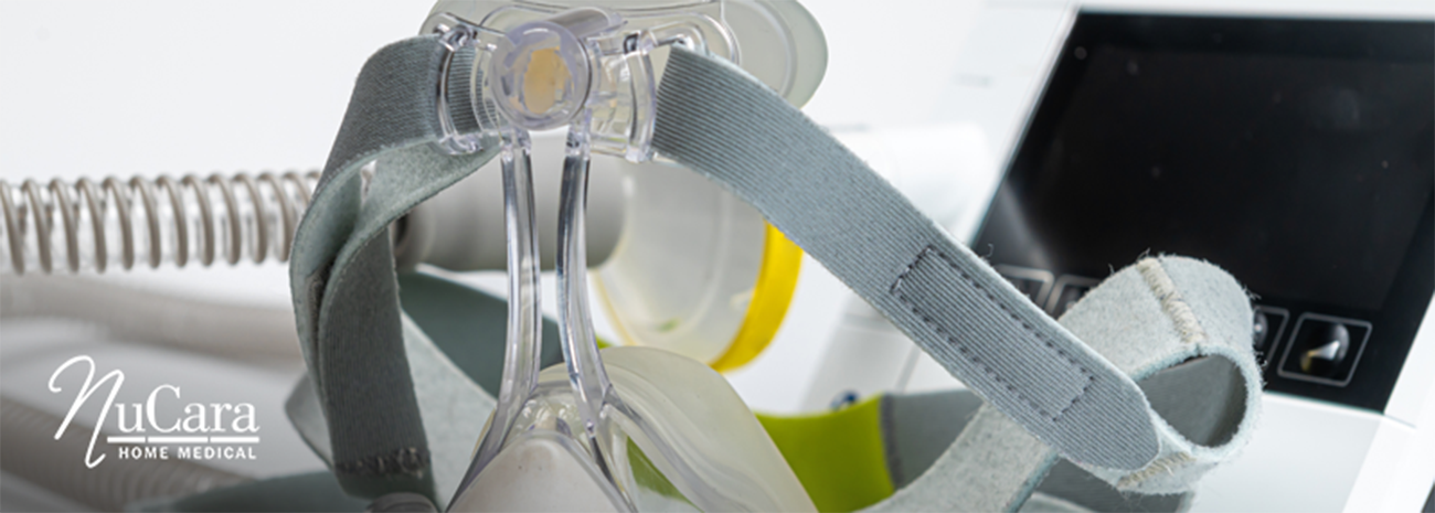 Close up of CPAP mask with CPAP machine and tubing behind it