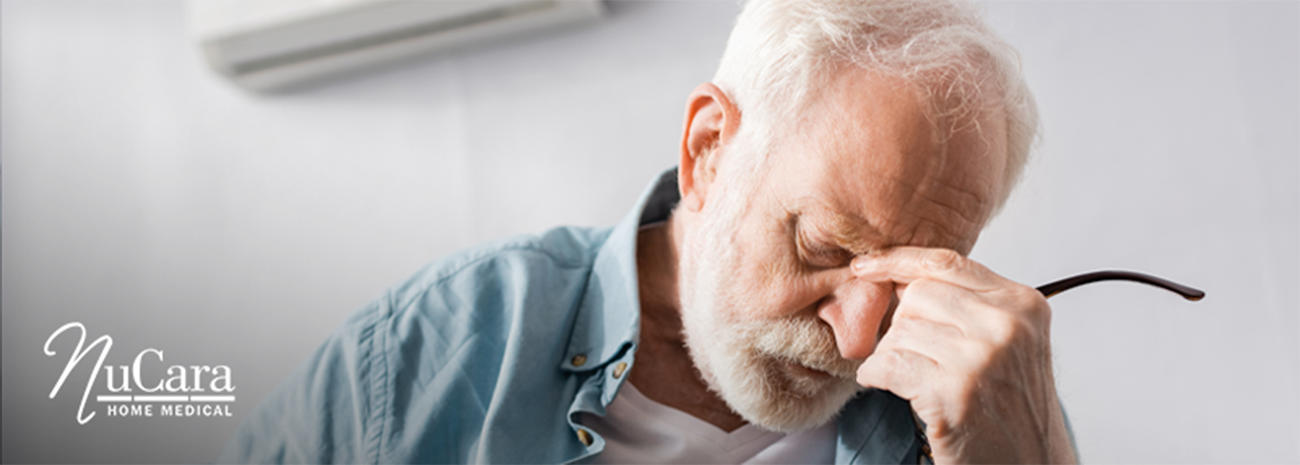 Older man pressing his fingers to the bridge of his nose