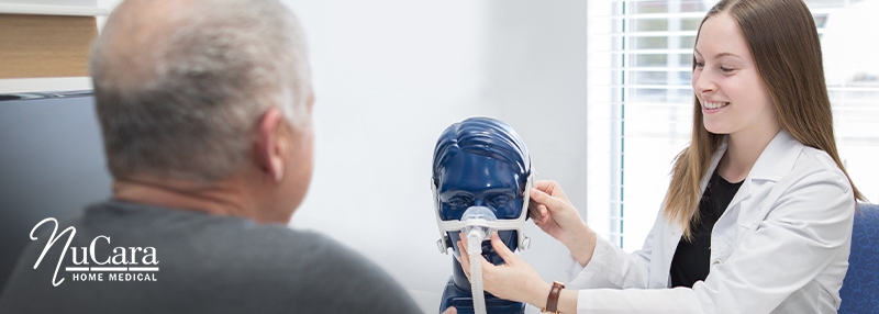 Female healthcare professional showing male patient how to put on CPAP mask