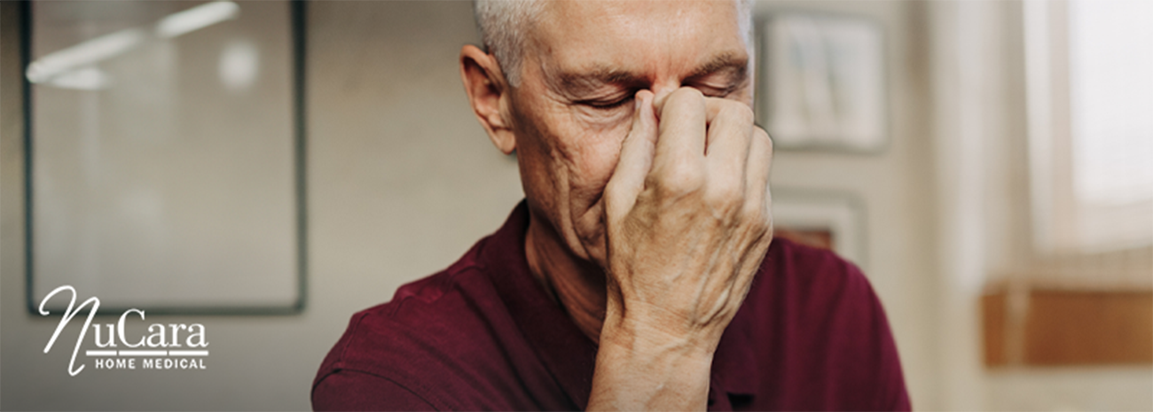 Man pinching the bridge of his nose like he has a headache