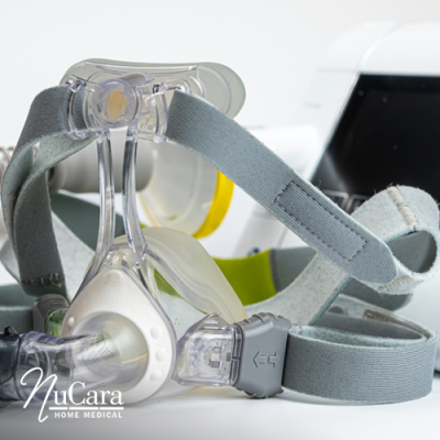 Close up of CPAP mask with CPAP machine and tubing behind it