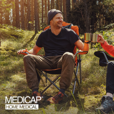 Image shows individual sitting in lawn chair in wooded environment