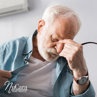 Older man pressing his fingers to the bridge of his nose